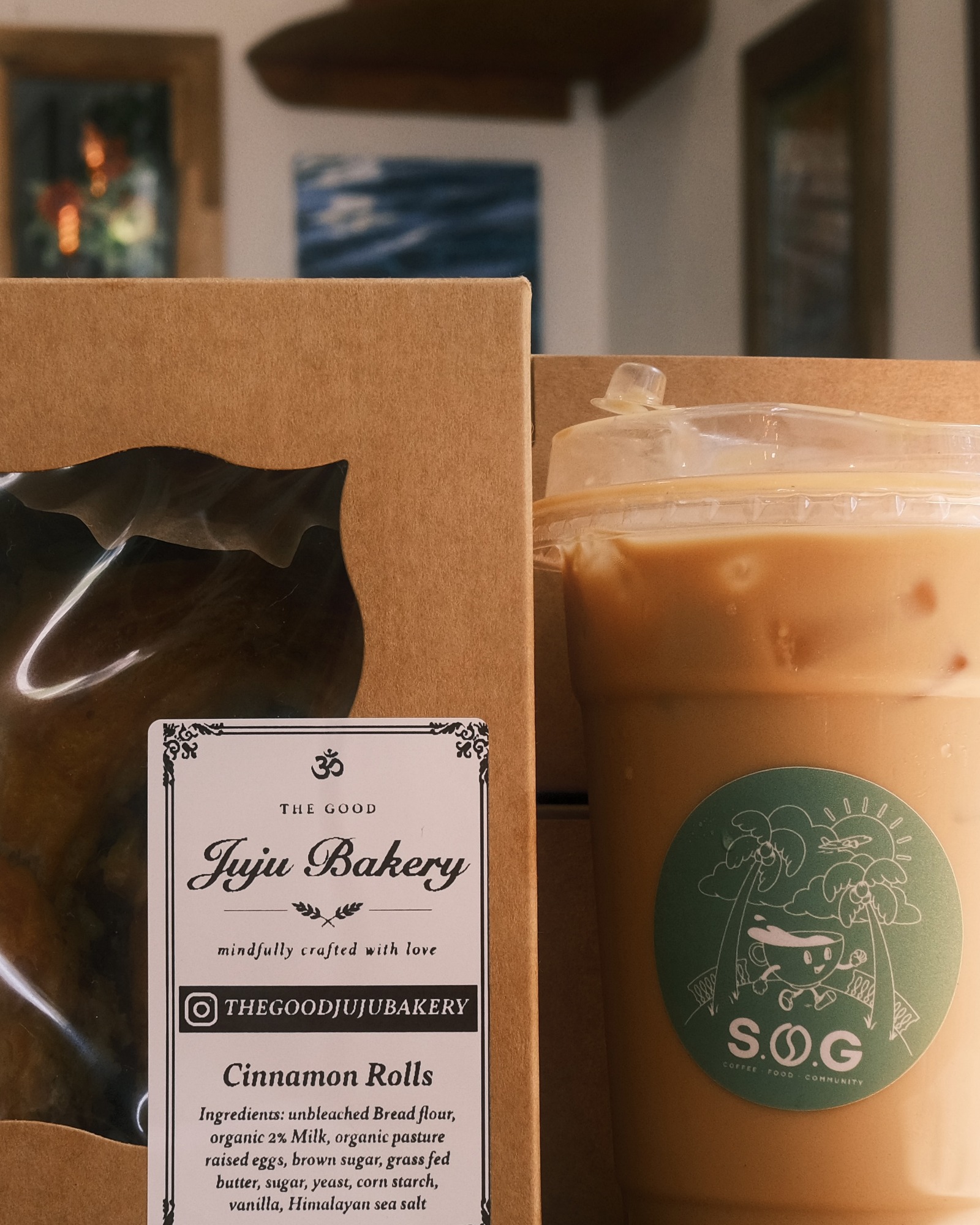 Good Juju Bakery Cinnamon Rolls box beside a SOG Café iced coffee